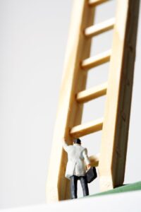 pexels-photo-12585536 a man in white coat toy standing beside the wooden ladder